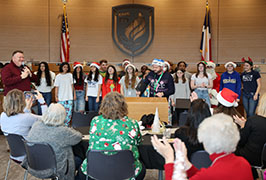  A group of students in the front with people in the audience clapping
